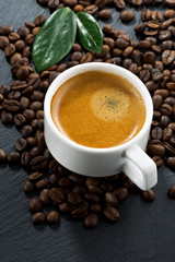 fresh espresso on coffee beans background, vertical, top view