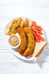 fried pork sausages with potatoes and mustard, top view