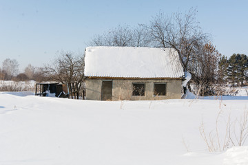 Houses in snow. The country house costs in snow.