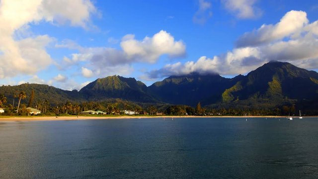 Hanalei Bay in Kauai Hawaii shows a stormy scene with sun shining through the clouds..