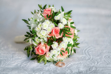 Close up of beautiful wedding bouquet with golden rings