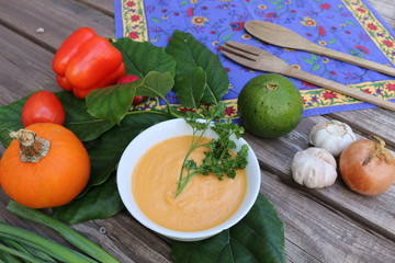 Pumpkin soup in Russian folk art khokhloma bowl with vegetables