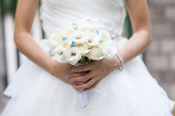 White roses wedding bouquet in bride's hand