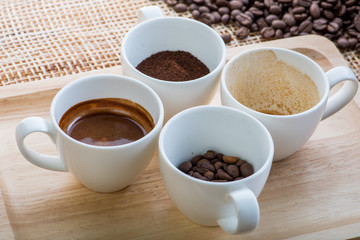 Cup of coffee on coffee beans background on a wooden table