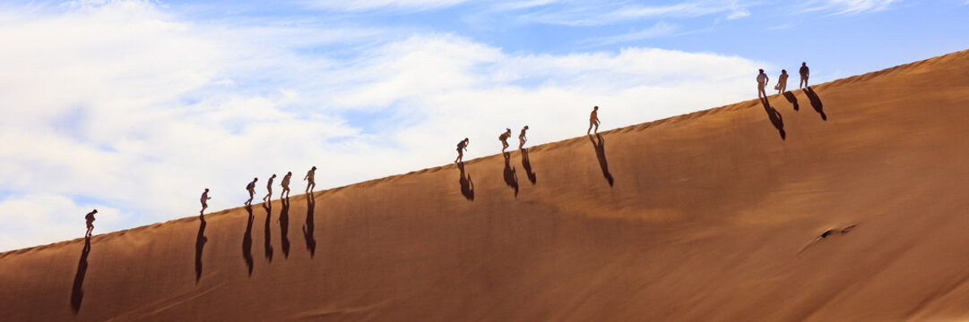 People Climbing A Dune In Sossusvlei Namibia