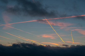 Fototapeta na wymiar Traces of the plane in the very beautiful and colorful sky before the sunset. Many planes crossroads in the sky.