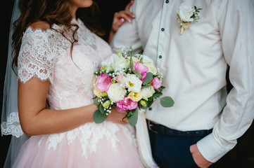 bride and groom holding a bouquet. wedding flowers