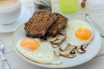 Healthy breakfast, fried eggs with mushrooms and two slices of r
