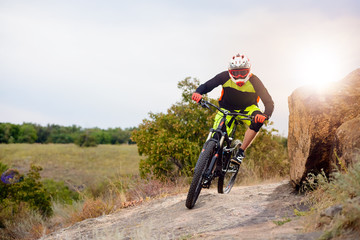 Fototapeta na wymiar Professional Cyclist Riding the Bike at the Rocky Trail. Extreme Sport Concept. Space for Text.