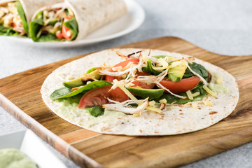 shredded barbecued chicken wraps with carrot, cheese, avocado an