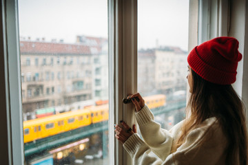 Young woman opening balcony windows in the morning