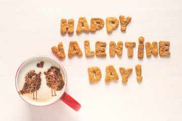 Happy Valentine's day greeting message made of homemade cookies and cup of coffee with decorated cinnamon kissing birds