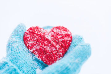 Blue knitted gloves with woolen heart. St. Valentine's Day greet