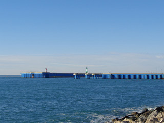 Lighthouses on pier, rocks and blue sea