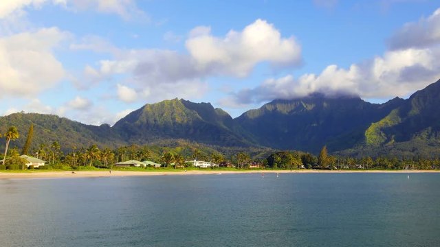 A time lapse of Hanalei Bay in Kauai Hawaii shows a stormy scene with a rainbow forming from the combination of rain and sunshine..