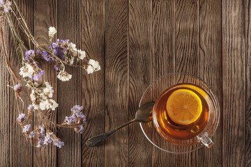 tea with lemon on a wooden table with wildflowers