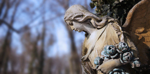 Vintage image of a sad angel on a cemetery against the backgroun