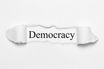Democracy on white torn paper