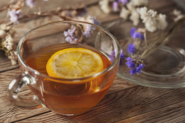 tea with lemon on a wooden table with wildflowers