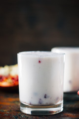 Traditional indian drink - lassi - cold yougurt dessert with the pomegranate seeds.