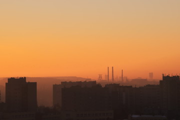 Fototapeta na wymiar Sunrise over the settlement with visible on the horizon coal mine