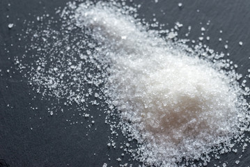 White sugar on the dark background