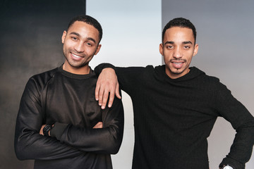 Two happy african american young men standing with arms crossed