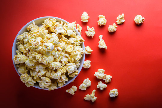 popcorn in white bowl on the red background