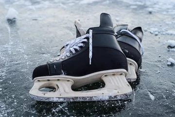 Afwasbaar fotobehang hockey scates on ice pond riwer © ygor28