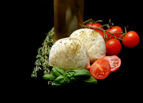 mozzarella, cherry tomatoes and basil on a black background