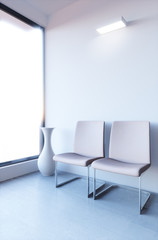 Empty lobby with chairs and white wall