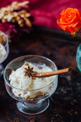 Delicious ice cream dessert in glass over black surface.