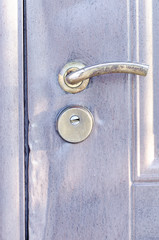 Metal door with traces of burglary with lock and door handle