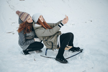 Fototapeta na wymiar Girls with sledge