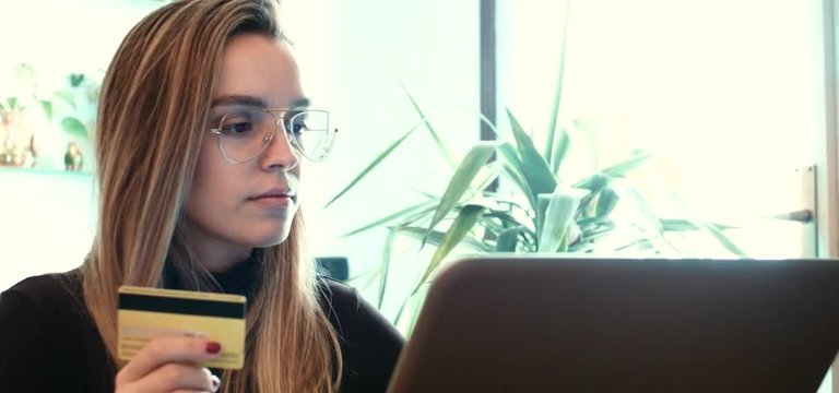 Donna con carta di credito e computer inserisce codici