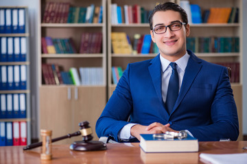 Handsome judge with gavel sitting in courtroom