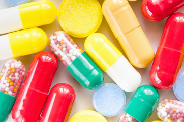 Colorful medicine pills, drugs and capsules on a white background. Selective focus. Close-up macro shot.