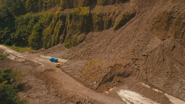 Landslides and rockfalls on the road in the mountains.Aerial view: mud and rocks blocking the road.Destroyed rural road landslide damaged in powerful flood. Collapsed on the mountain. Philippines