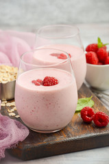 Raspberry and banana smoothie with oatmeal on the rustic wooden table, selective focus, vertical