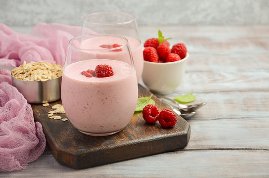 Raspberry and banana smoothie with oatmeal on the rustic wooden table, selective focus, horizontal, copy space