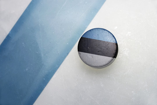 old hockey puck with the national flag of estonia.
