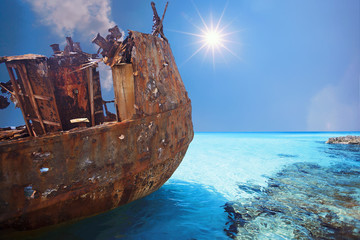 Old and Corroded metal ship at daylight with blue water