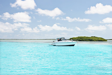 Obraz na płótnie Canvas Small riding boat near island on sea
