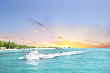 White boat sails the sea from the sundown horizon