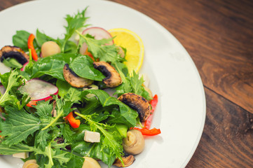 Fresh spring salad. Wooden background