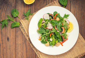 Fresh spring salad. Wooden background