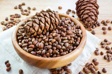Спелые кедровые шишки и кедровые орехи в деревянной тарлеке
