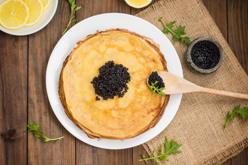 Black caviar on Russian pancakes - blini. Selective focus.