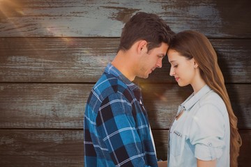 Composite image of couple standing head against head 