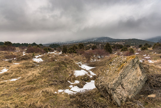 Dramatic winter landscape with foggy mountain and a big stone. Russia, Stary Krym.